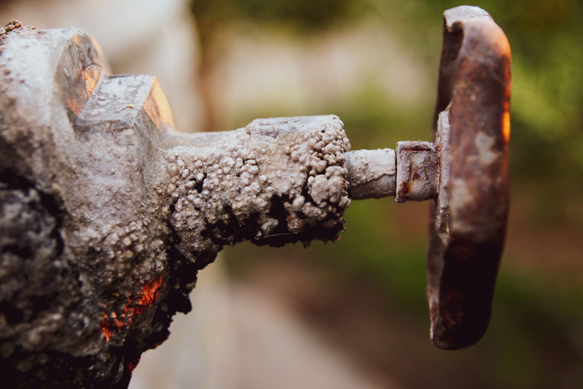 White calcium carbonate mineral scale buildup on an outdoor faucet — visible within months in hard water cities