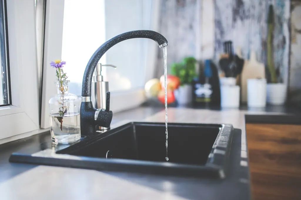 Kitchen sink with running water and hard-water film