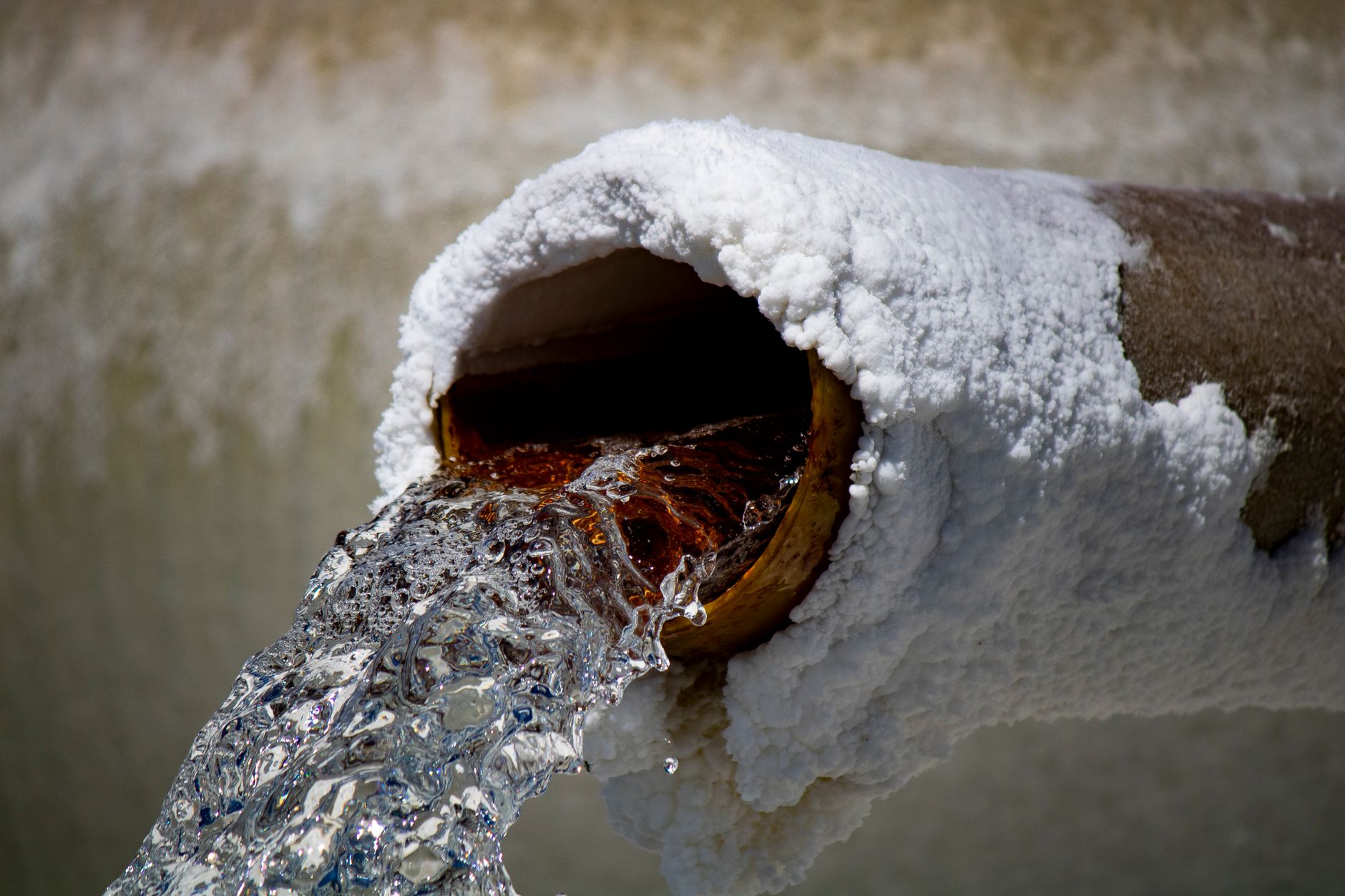 White salt and mineral deposits on a pipe from hard water — signs of hard water in Washington