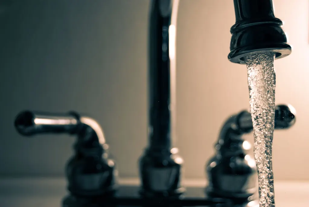 Clear water flowing from a steel faucet — recommended for Campbell River hard water treatment